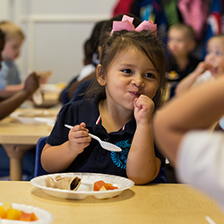 little girl eating and smiling